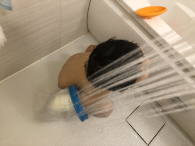 ギプスカバーをつけて入浴する子供